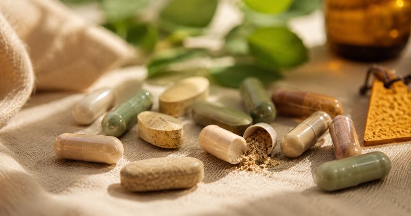 Quatre capsules de compléments alimentaires avec halos colorés symbolisant les erreurs de supplémentation